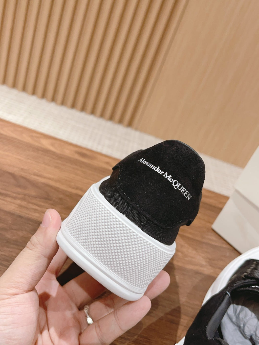 Black sneaker with white sole and Alexander McQueen branding on heel collar