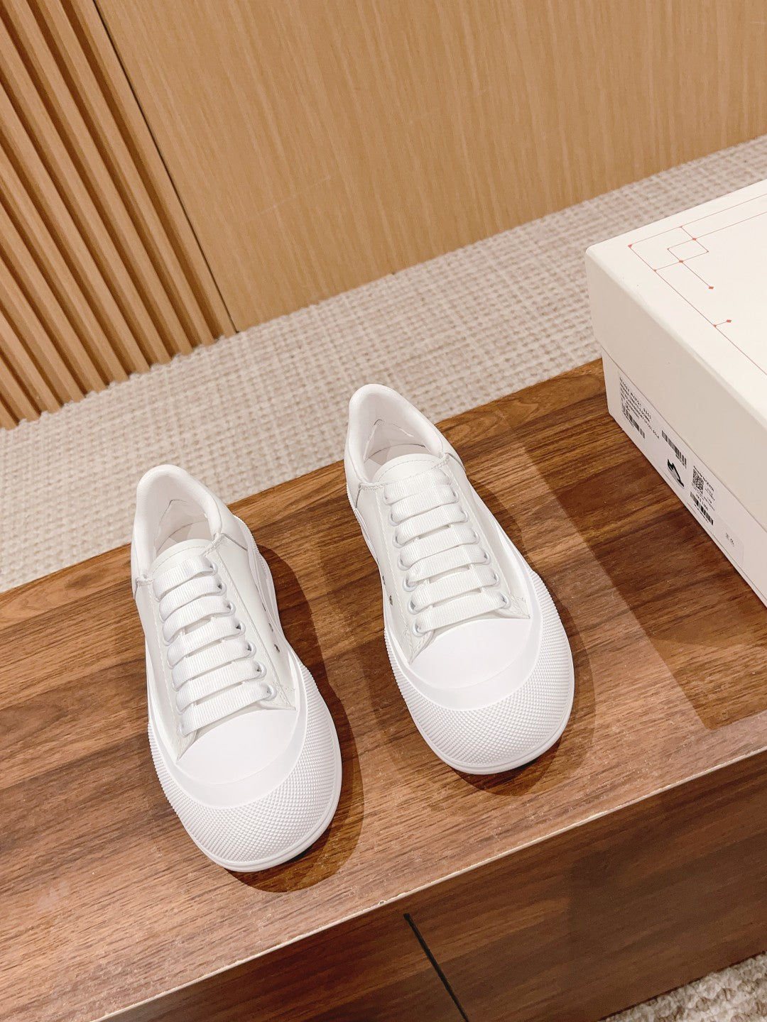 Pair of white low-top lace-up sneakers with rounded toe and ridged rubber sole
