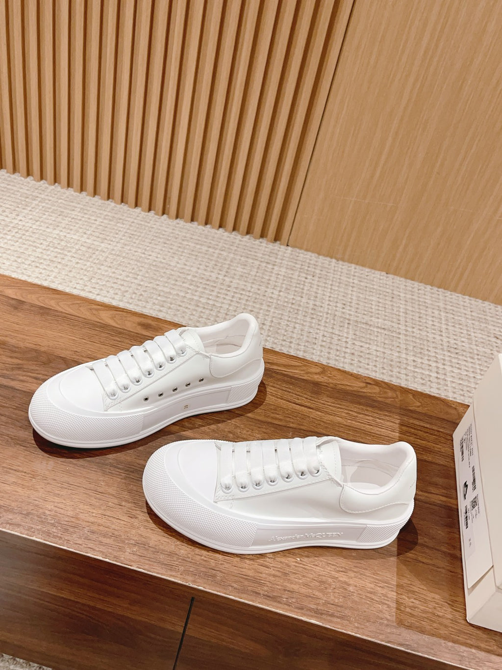 White low-top lace-up sneakers with perforated detailing and smooth leather upper