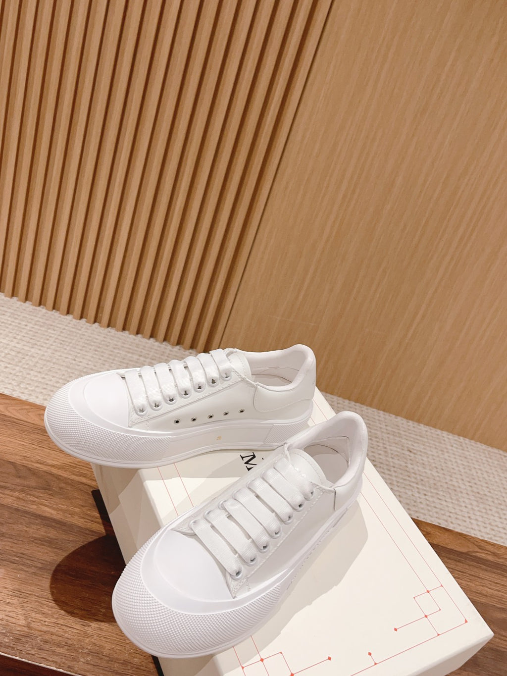 White lace-up sneakers with textured sidewall and stitched upper panels