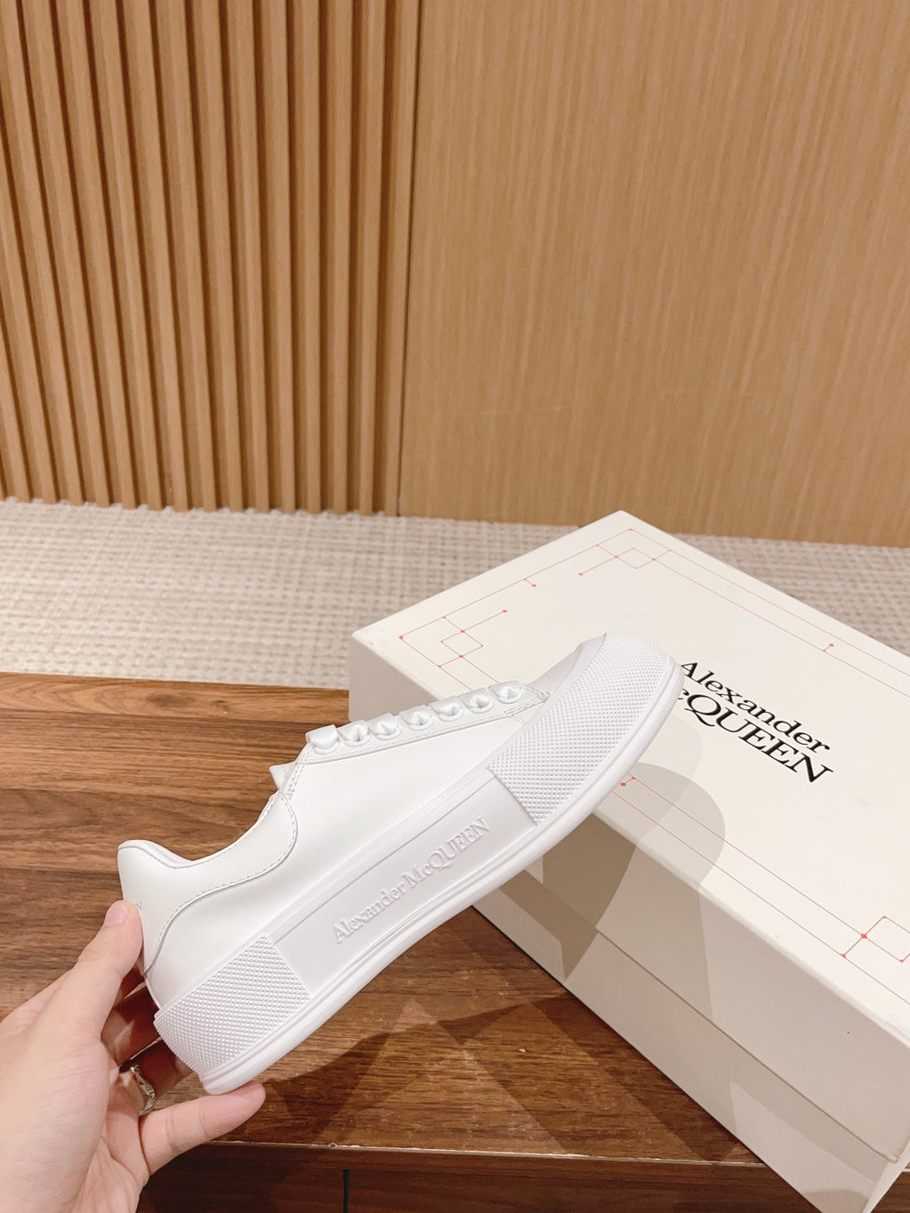 White low-top lace-up sneakers with textured rubber sole and side stitching detail