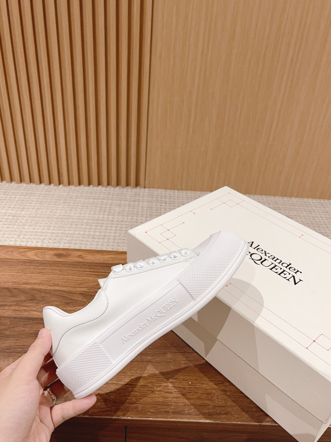 White low-top lace-up sneakers with textured rubber sole and side stitching detail