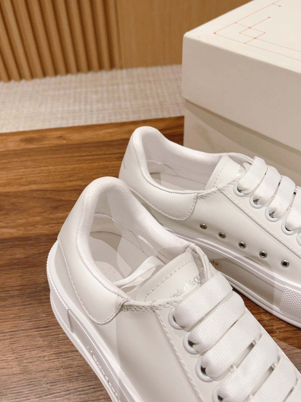 White sneakers with lace-up front, padded collar, and perforated eyelets