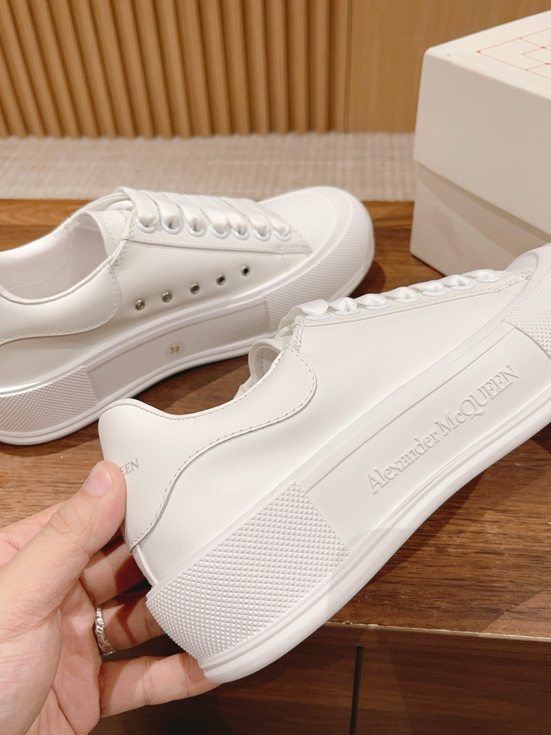 White low-top lace-up sneakers with textured sole and small side branding print