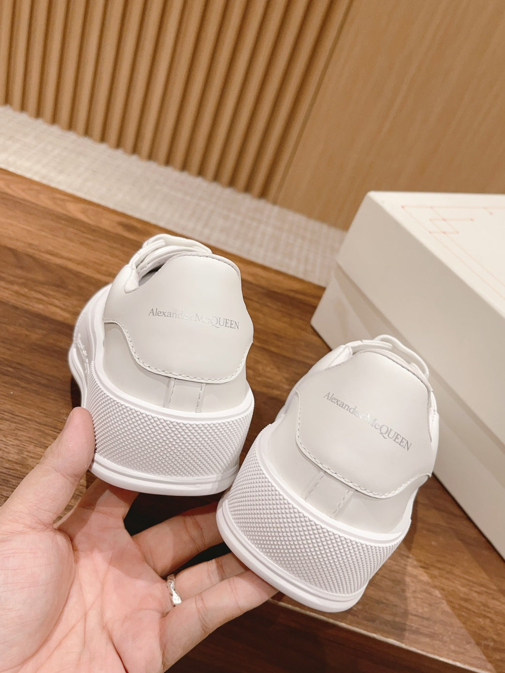 Back view of white low-top sneakers with cushioned heel and small logo text