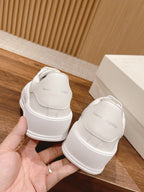 Back view of white low-top sneakers with cushioned heel and small logo text