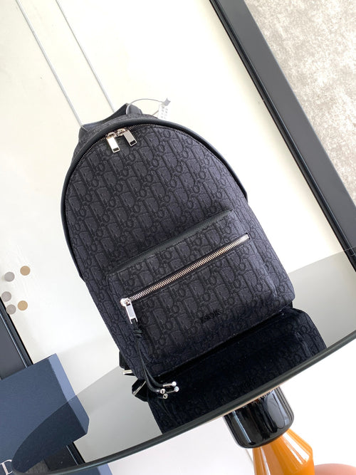 Dior men's monogram backpack with front zip pocket, silver pulls, and top handle
