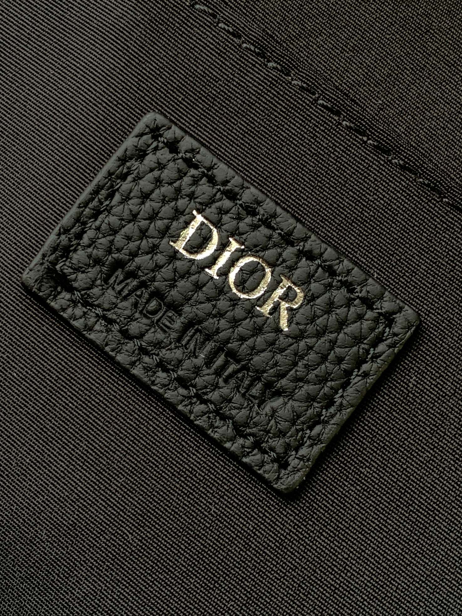 Dior logo patch on quilted dark fabric inside the backpack.