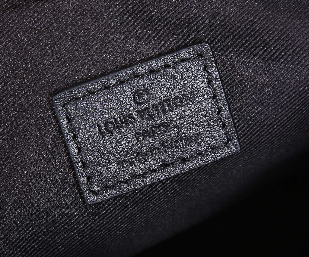 Louis Vuitton monogram bag leather logo patch with embossed branding, close-up
