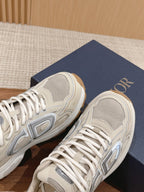 Dior unisex sneakers side view with gray logo and white laces, light beige upper