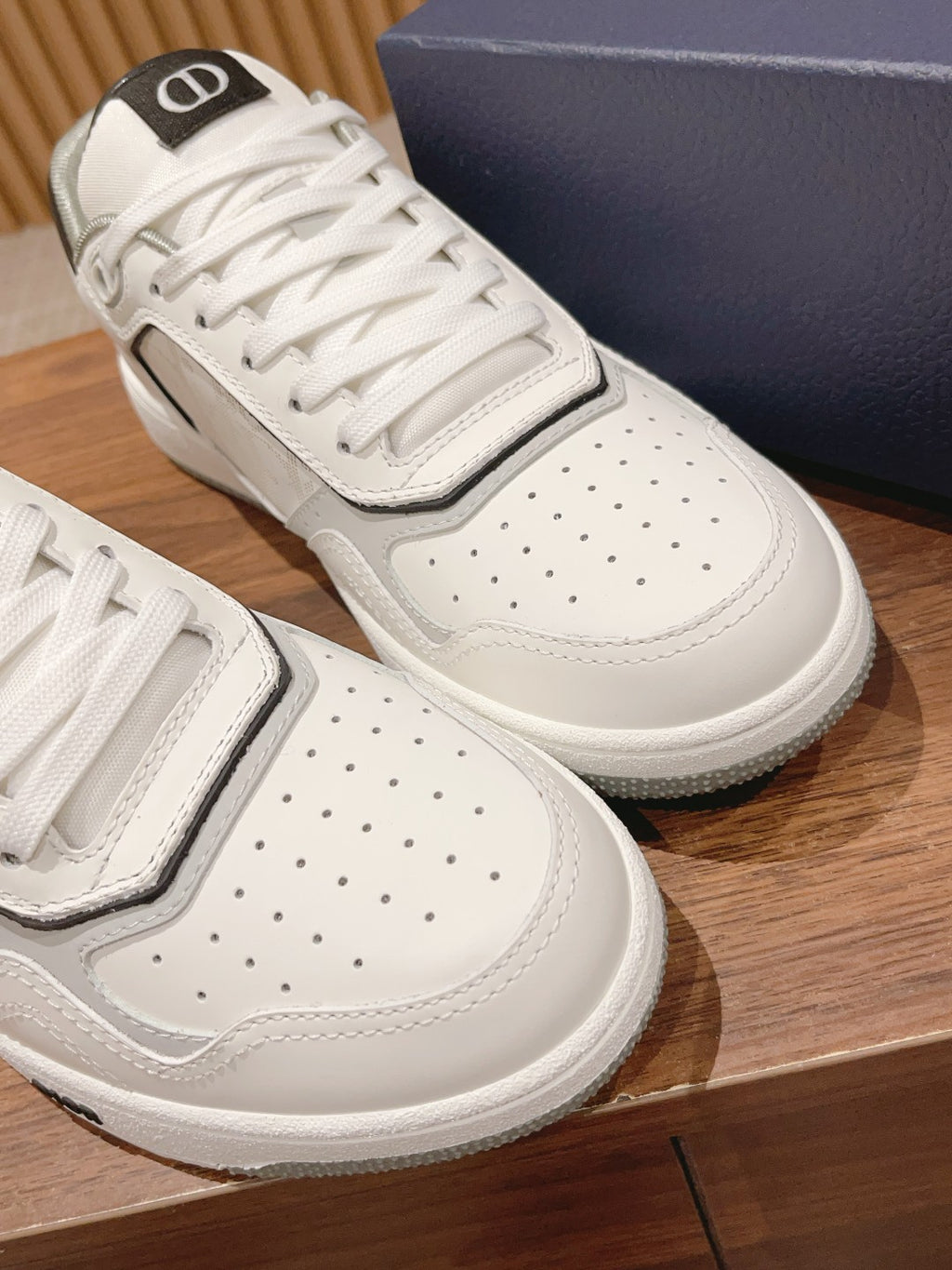 Dior unisex luxury shoes, pair view of white sneakers with perforated toe and gray side trim