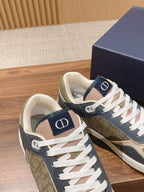 Dior low-top sneakers with navy uppers, cream laces, and 'D' patch on tongue