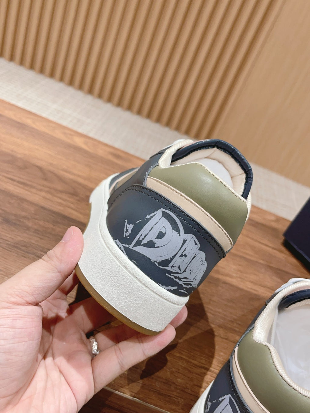 Dior low-top sneaker heel detail in navy with white logo graphic and contrast trim