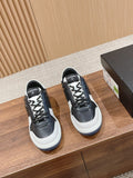 Black and white lace-up sneakers with white rubber sole and Chanel logo patch