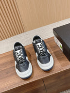 Black and white lace-up sneakers with white rubber sole and Chanel logo patch