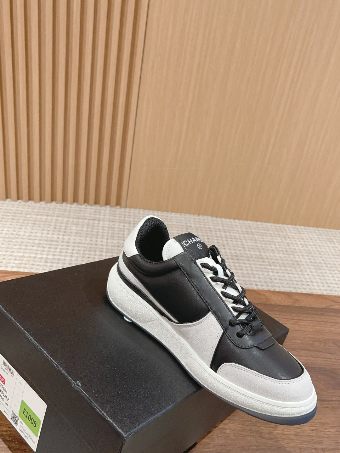 Black leather low-top sneakers with white sole and black tongue logo