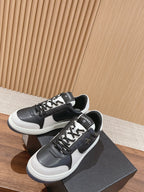 Pair of black and white low-top sneakers with lace-up front and side emblem