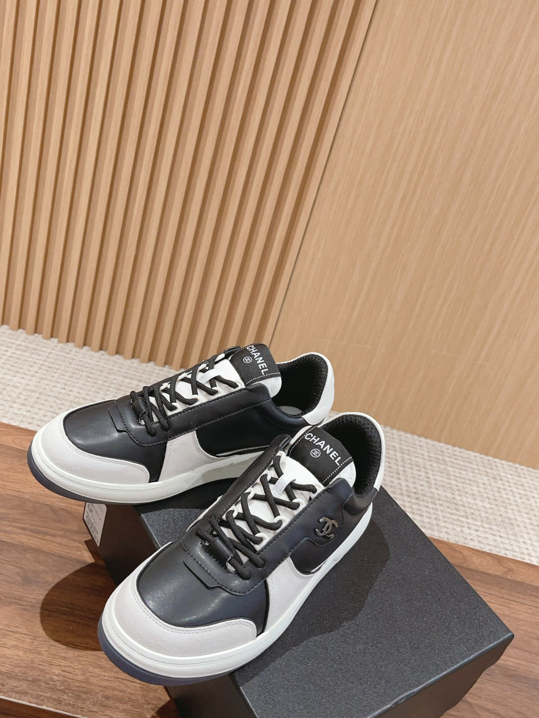 Pair of black and white low-top sneakers with lace-up front and side emblem