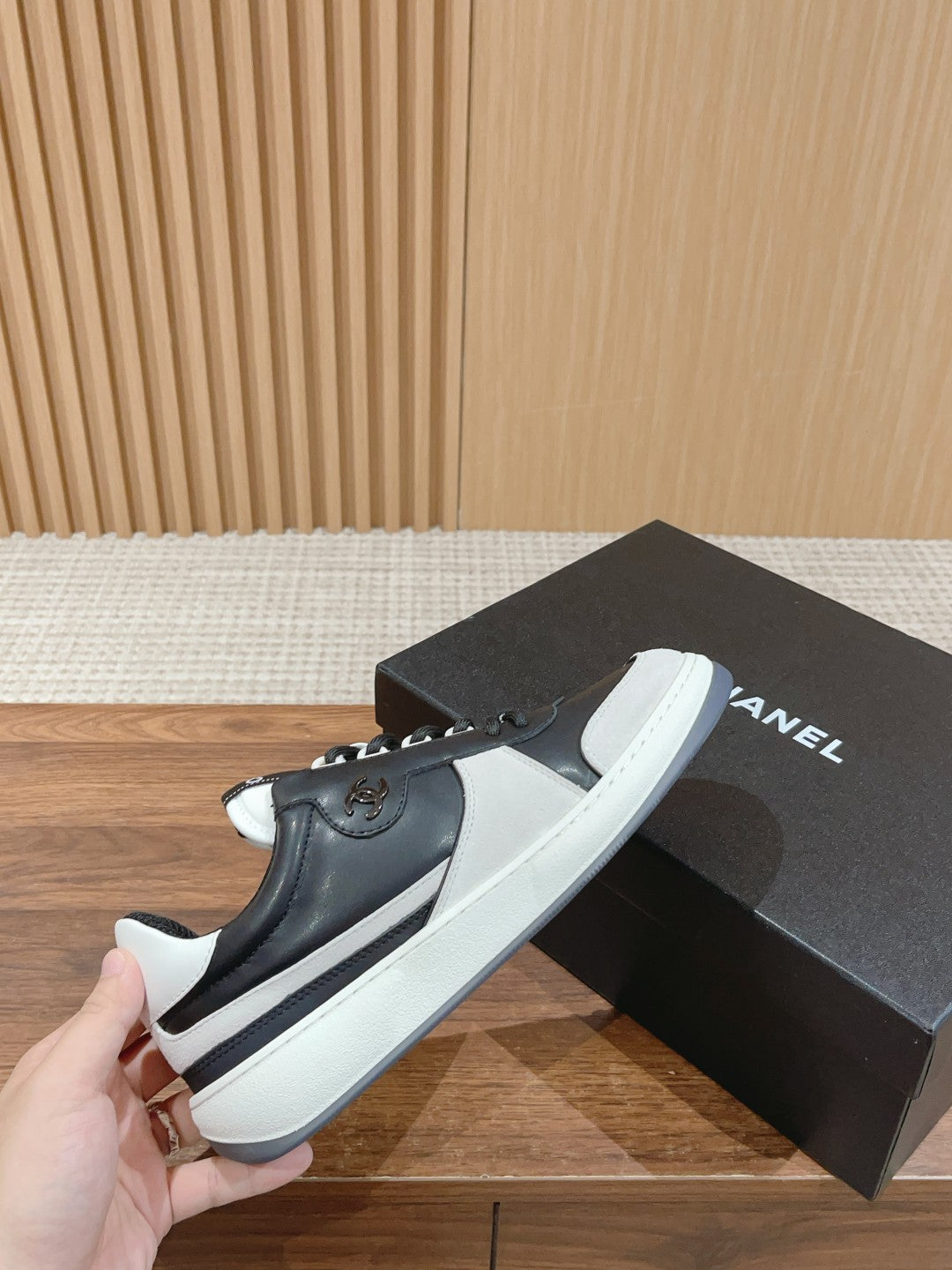 Hand-held black and white slip-on sneakers with white platform sole and logo