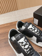 Black and white lace-up sneakers with Chanel logo on tongue and heel patch