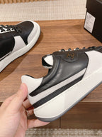 Black and white sneaker with gold emblem on side and grippy white sole