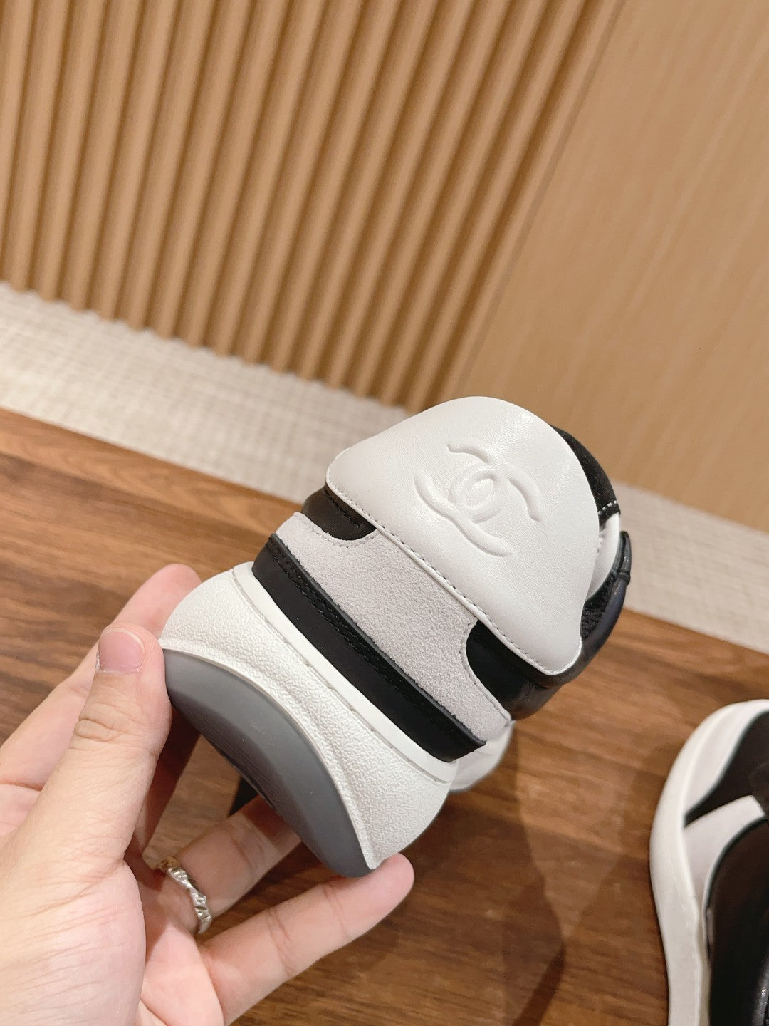 White sneaker heel with embossed Chanel logo and black ankle strap