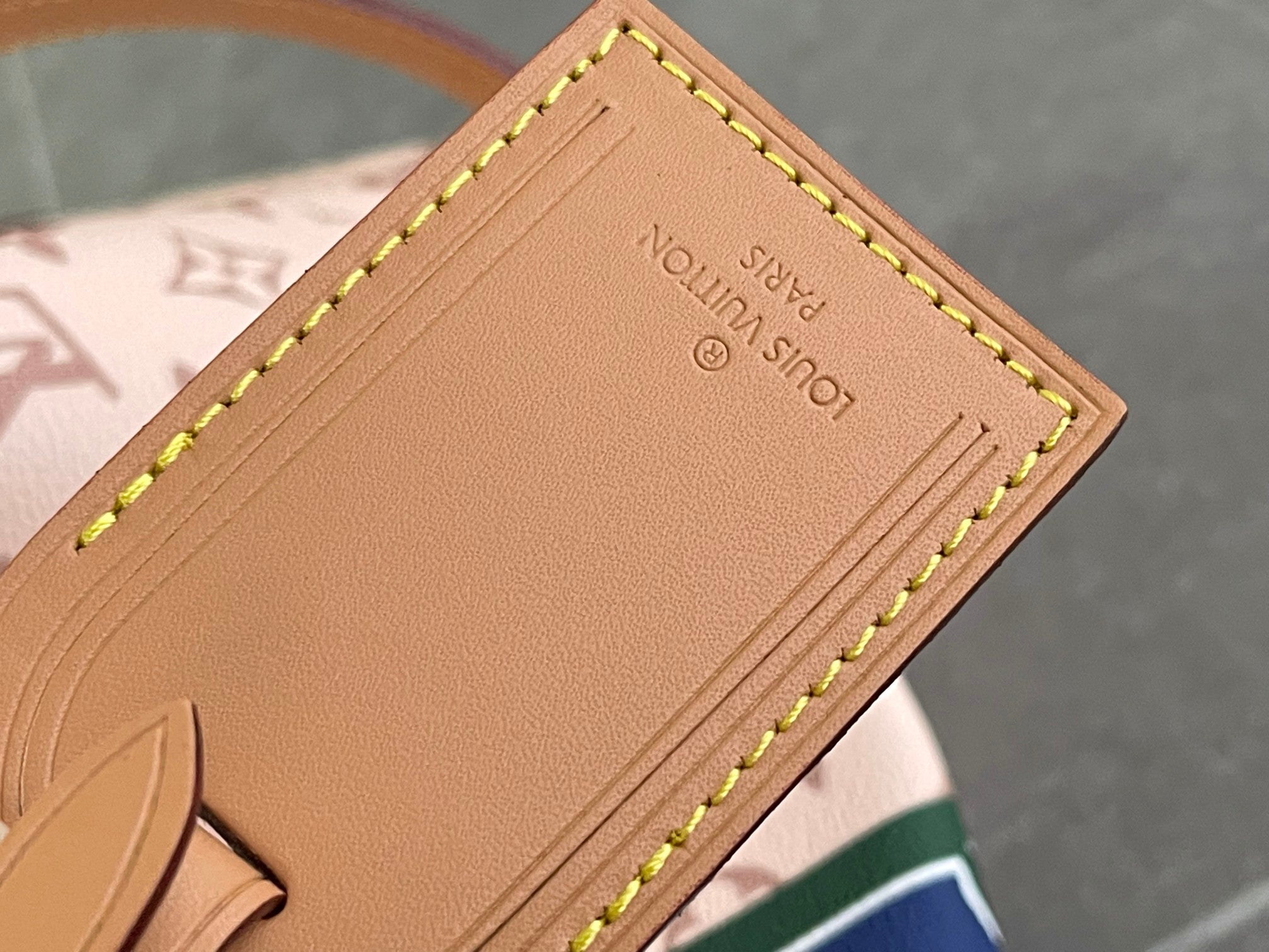 Beige leather inside label with stitched edges and embossed text