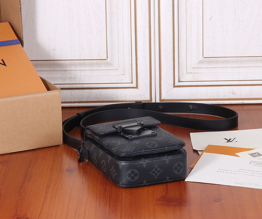 Louis Vuitton monogram crossbody bag lying flat with shoulder strap across the top.