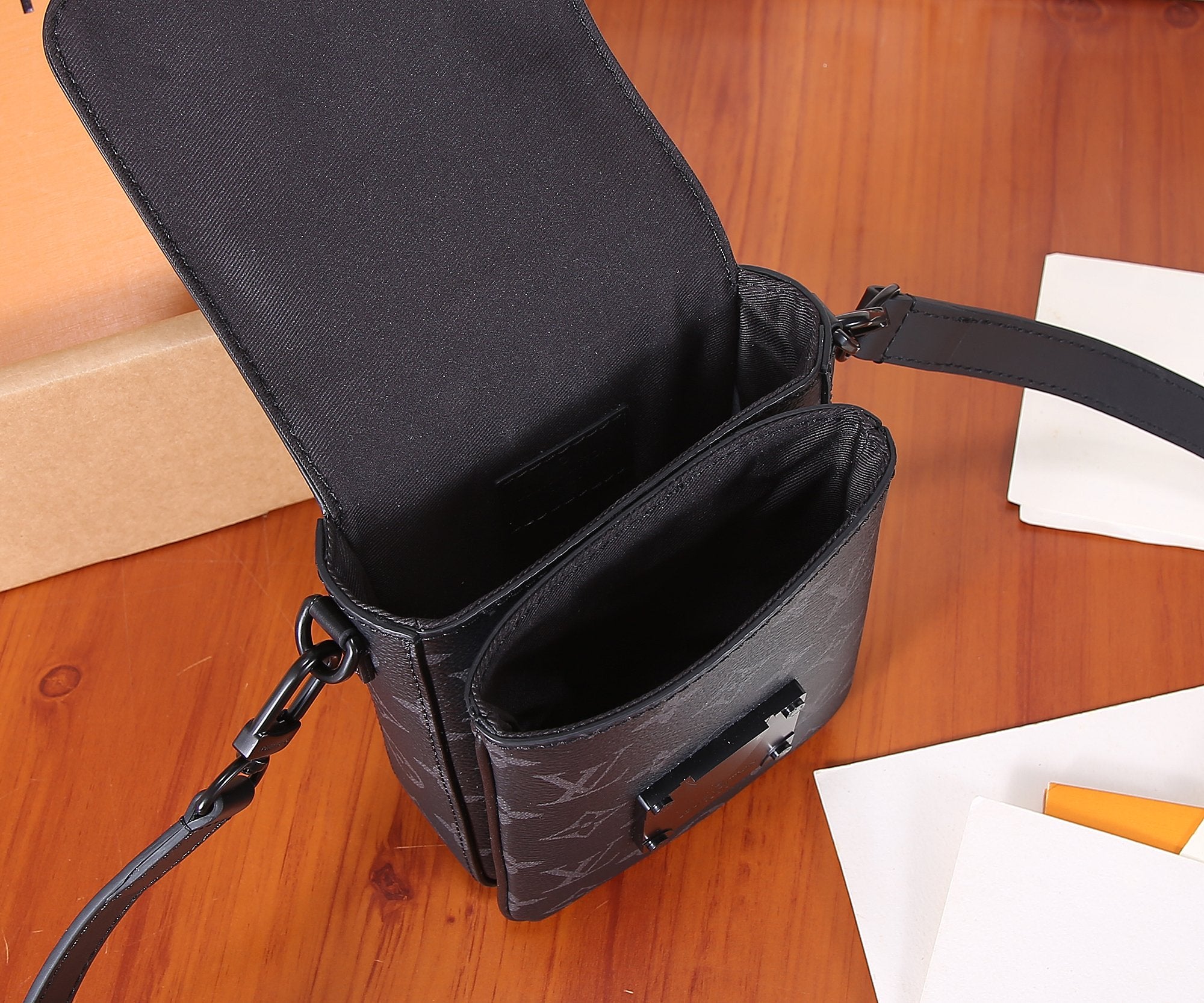 Louis Vuitton monogram crossbody bag with open top and front pocket, dark finish.
