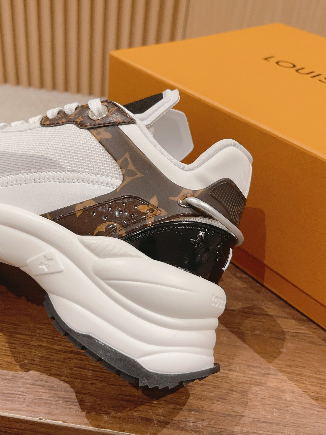Louis Vuitton unisex sneakers close-up, dark brown monogram side, white chunky sole