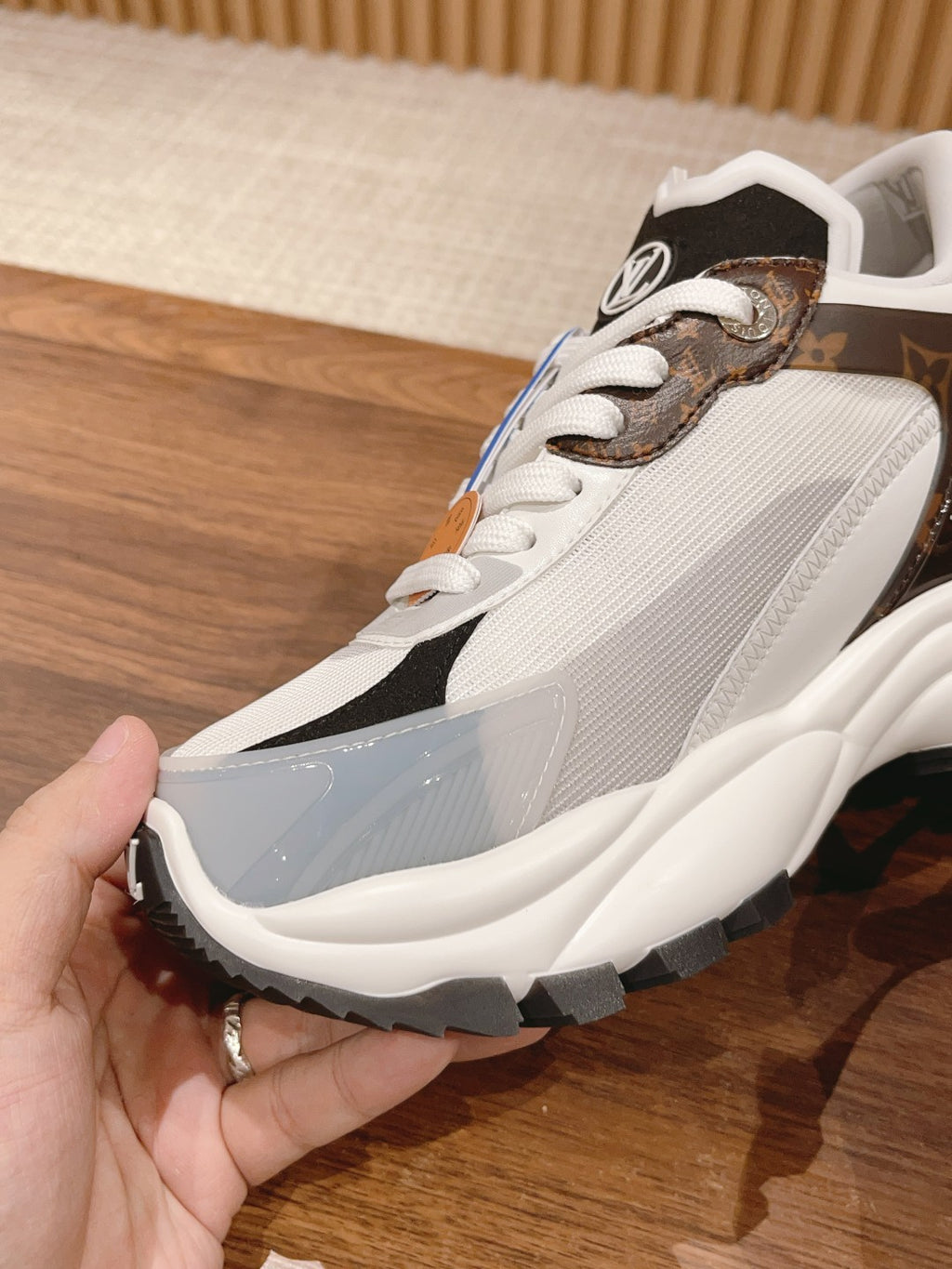 Louis Vuitton unisex sneaker close-up, white upper with brown/black monogram laces