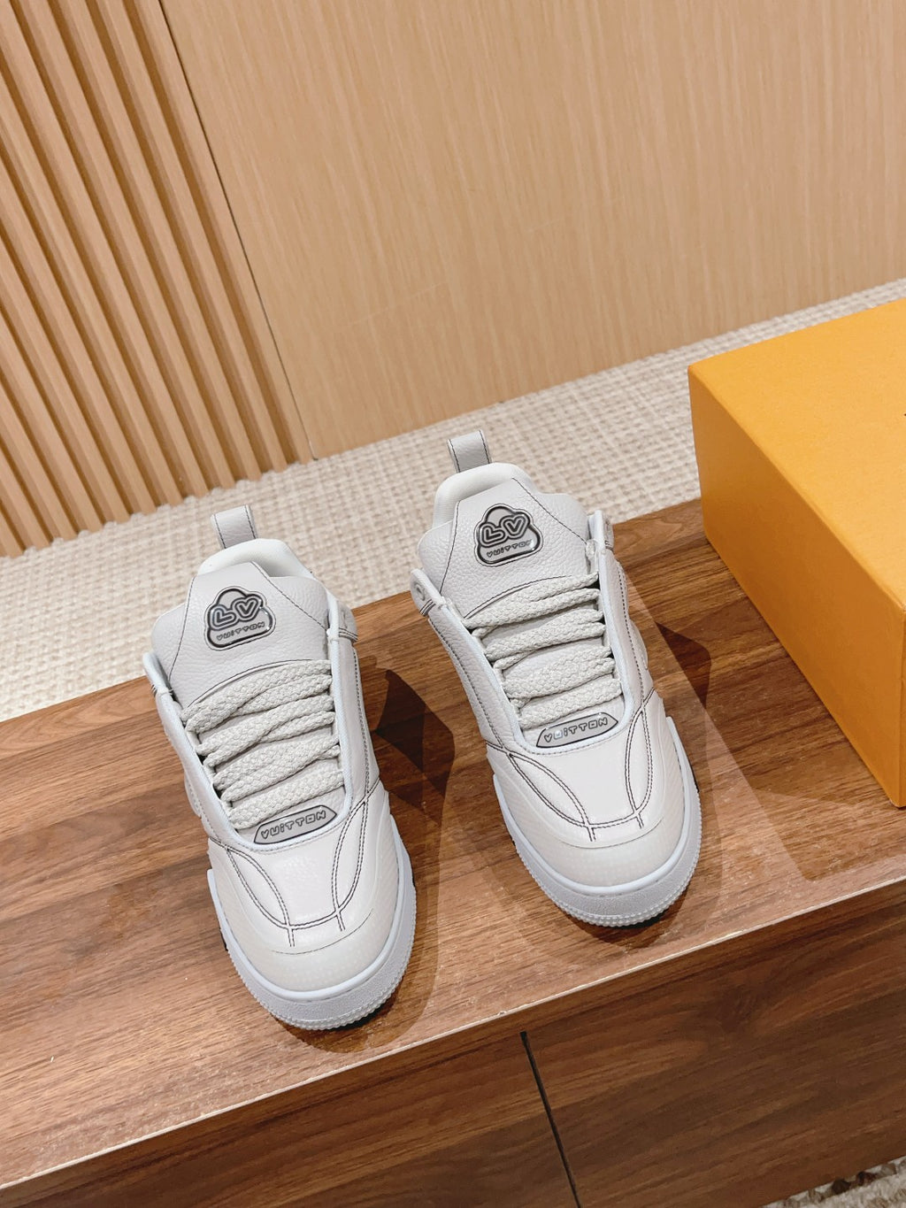 White Louis Vuitton leather sneakers, lace-up, logo patch on tongue, paired side view