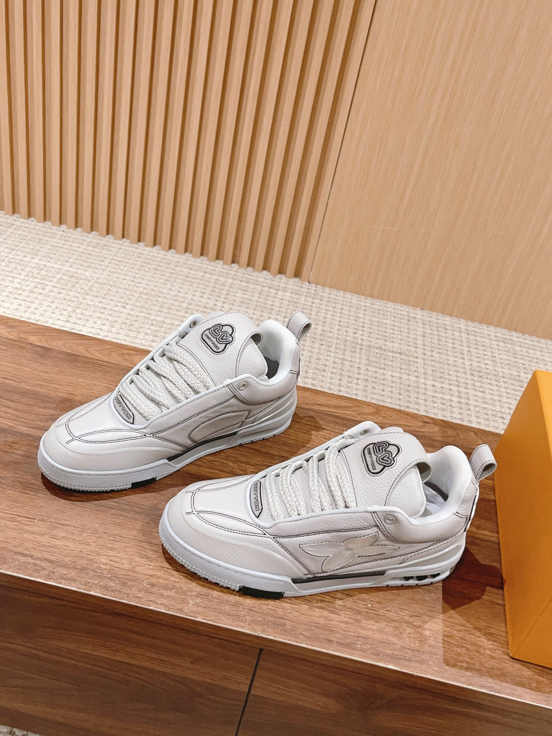 White Louis Vuitton leather sneakers, lace-up, low-top profile view of two shoes