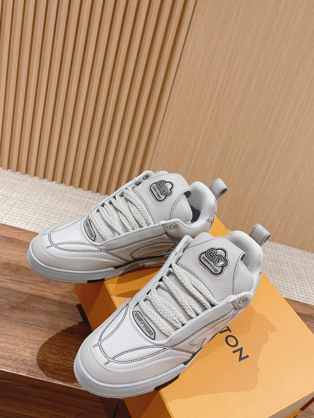 White Louis Vuitton leather sneakers, lace-up, angled front and side view of pair