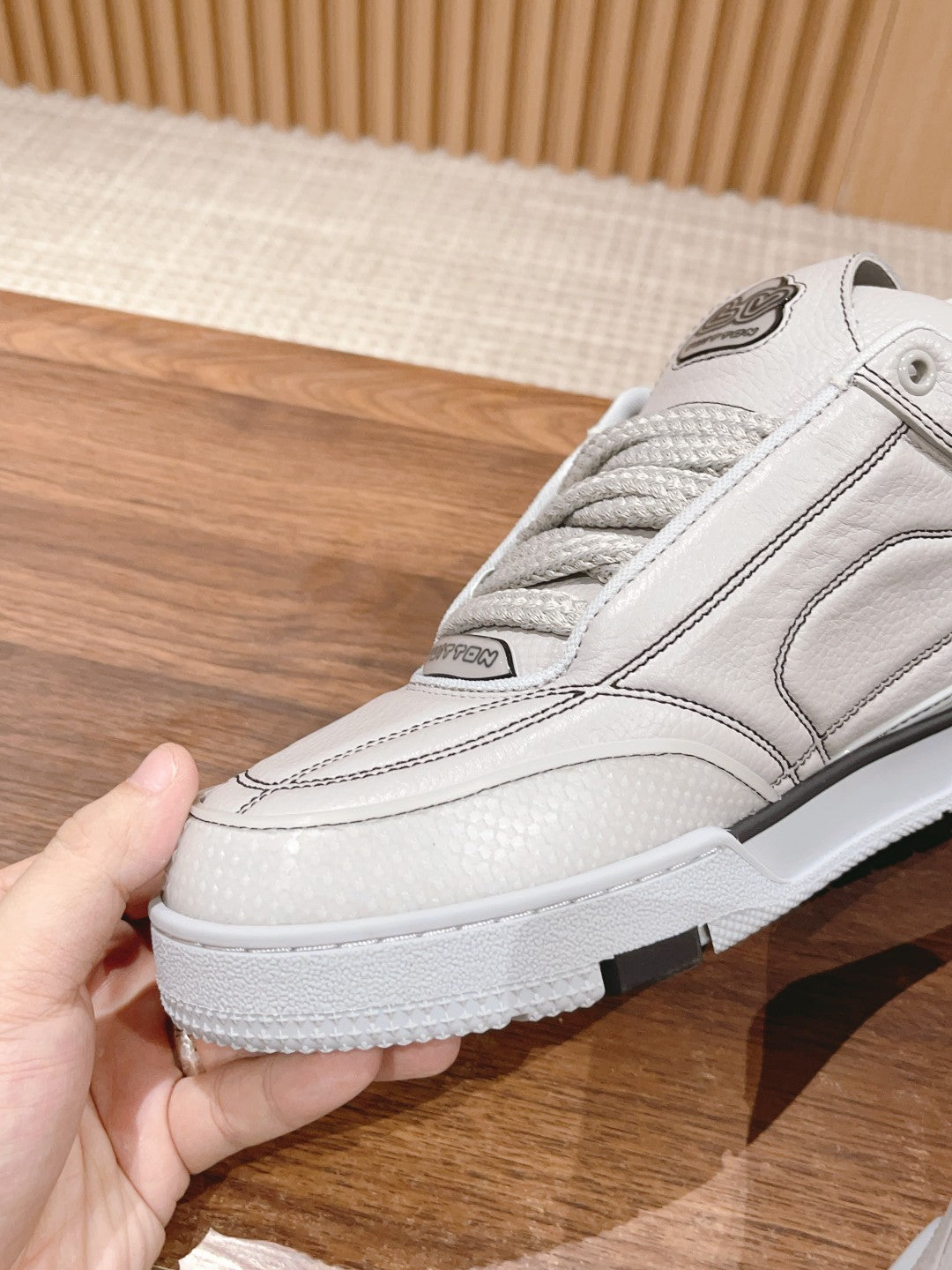White Louis Vuitton leather sneaker, lace-up with side logo detail, close-up