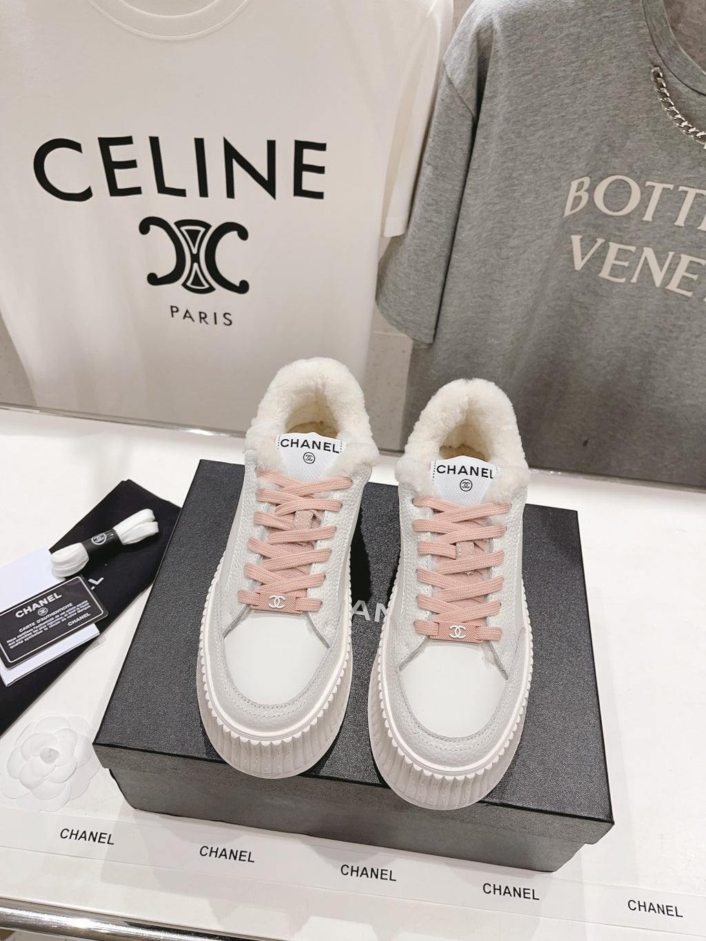 Chanel white low-top sneakers with pink lace-up detailing and plush sherpa lining