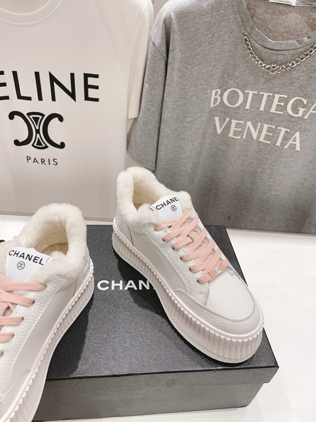 Chanel white low-top sneakers with pink lace-up fronts and sherpa-lined interiors