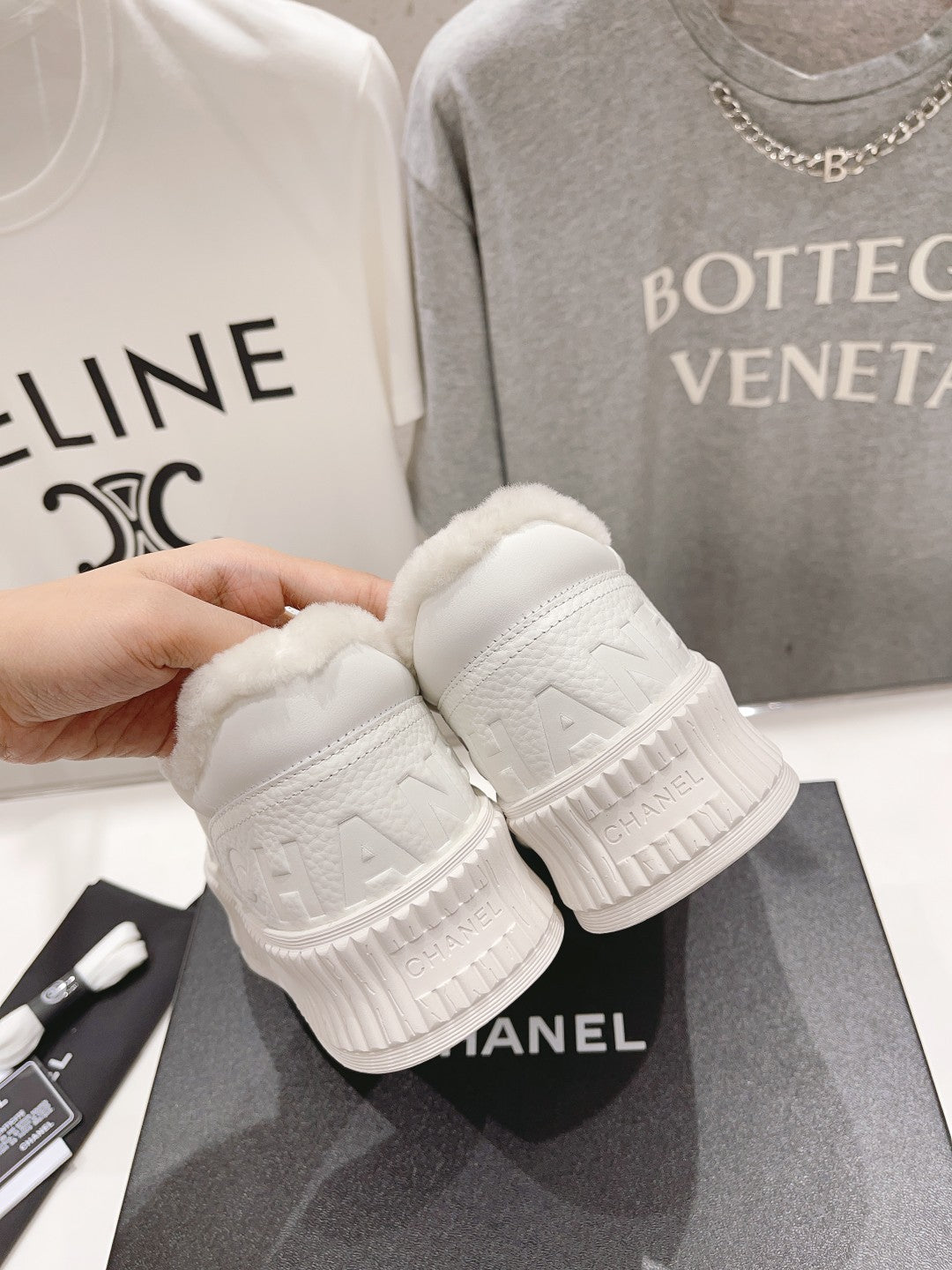 Chanel white sneakers displayed with textured rubber outsoles and sherpa-lined collars