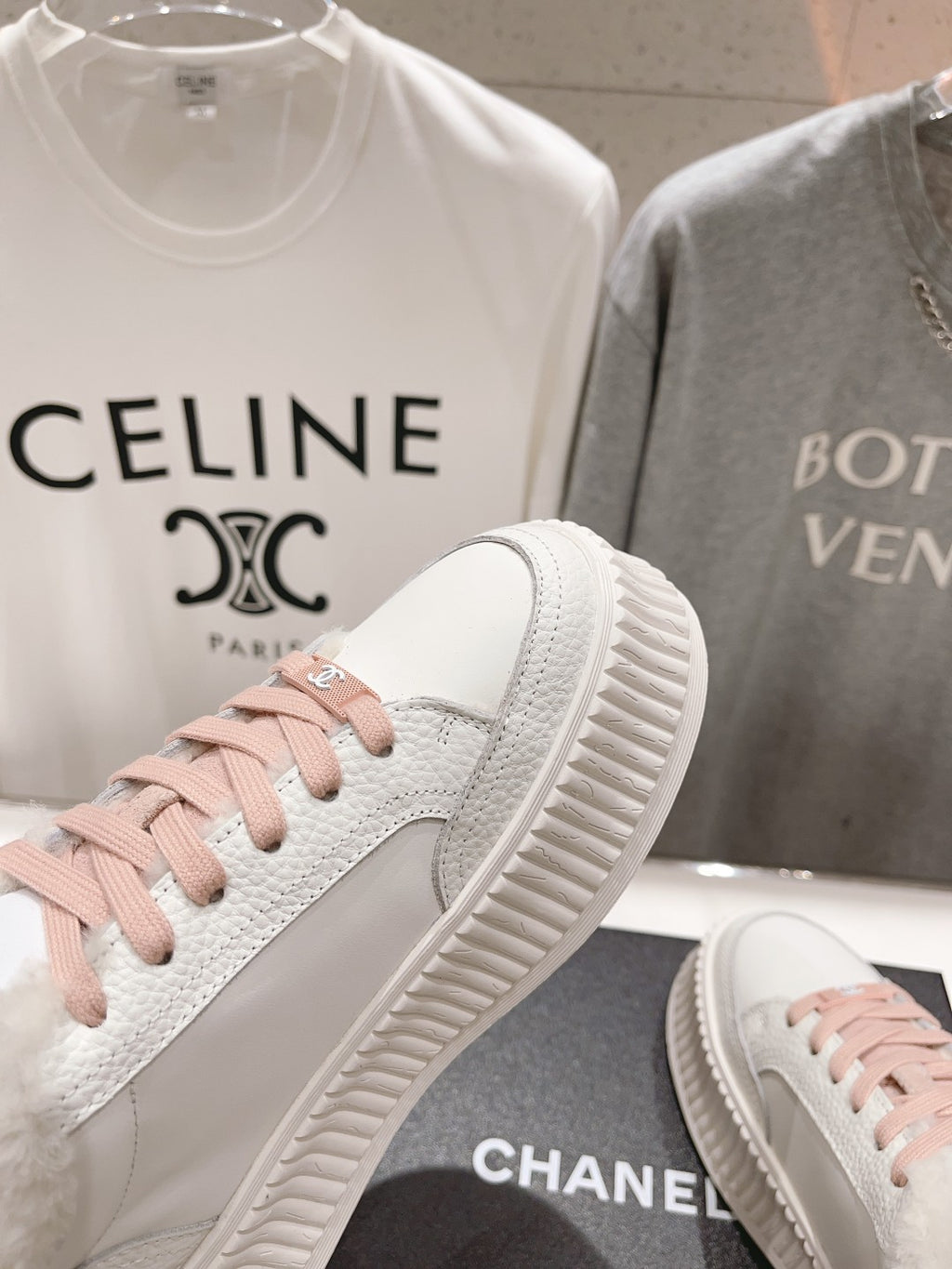 Chanel white sneaker side view with pink lace-up accents and chunky sole