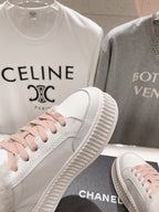 Chanel white sneaker side view with pink lace-up accents and chunky sole