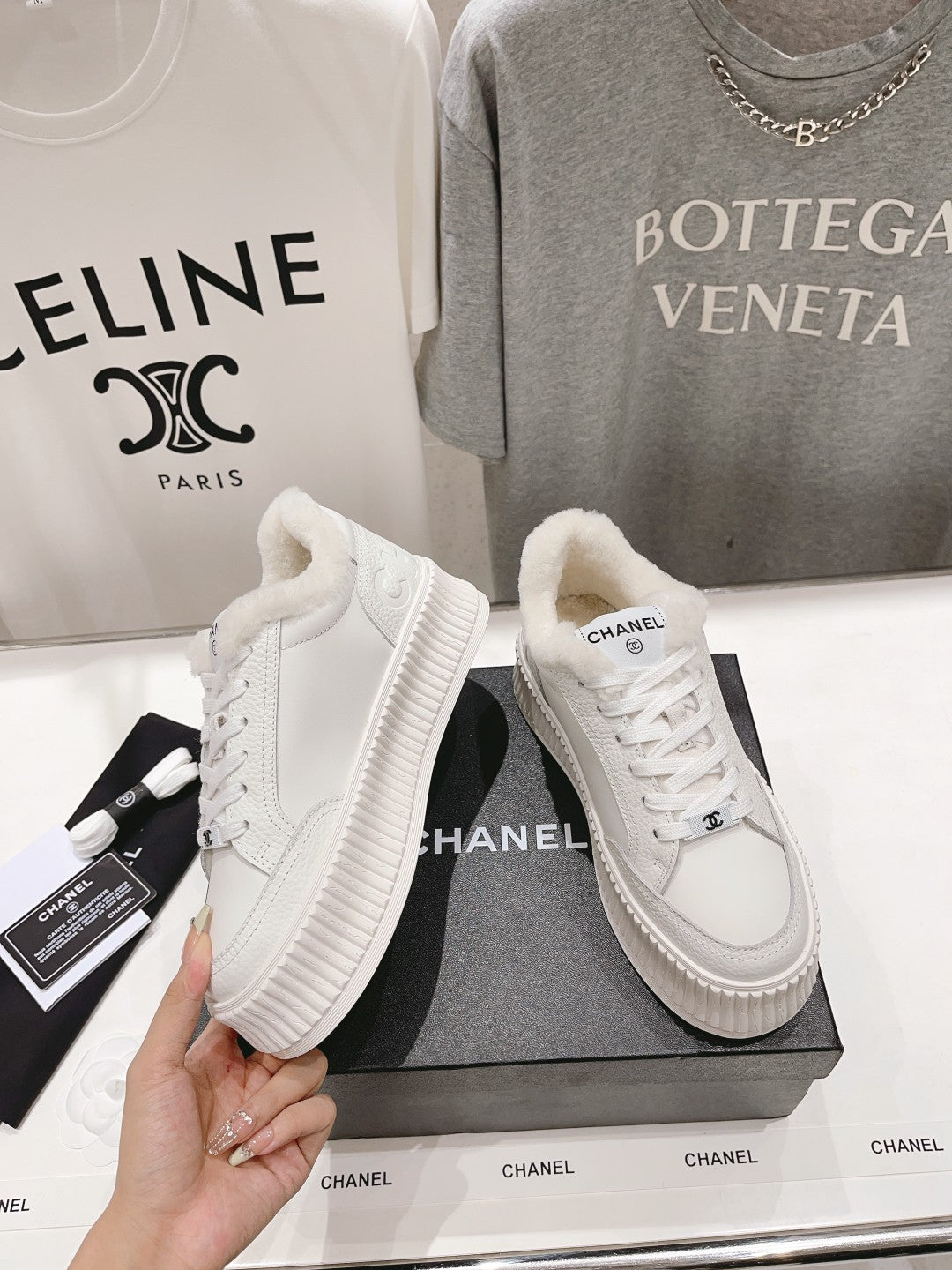 Pair of white lace-up sneakers with plush collar and ribbed platform sole
