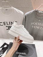 White lace-up sneaker with plush collar and ribbed platform sole, side view