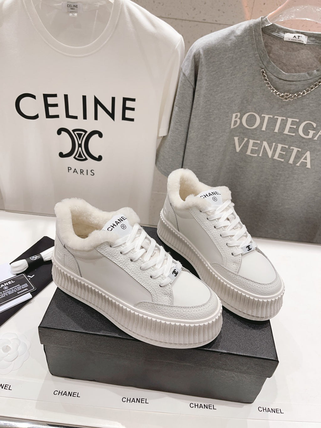 Two white lace-up sneakers with plush collars and textured platform soles