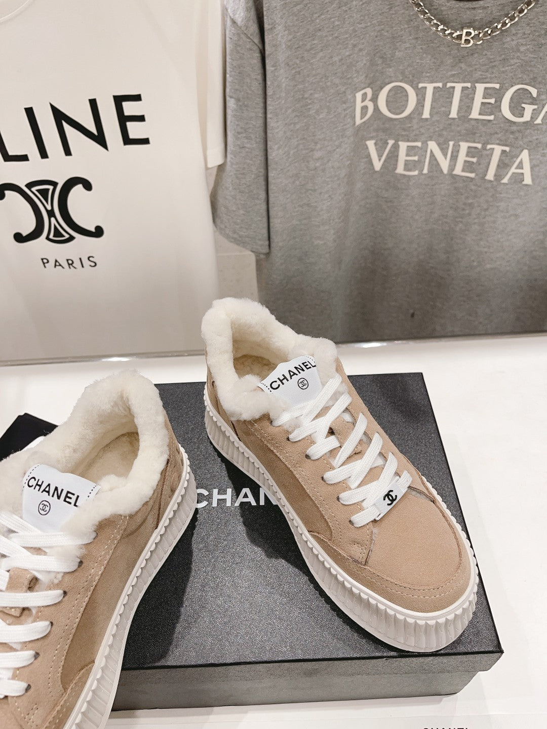 Women’s beige Chanel sneakers with plush shearling collar and white lace-up front