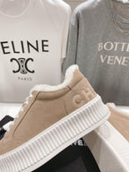 Women’s beige Chanel suede sneakers with white ribbed sole and plush fur collar
