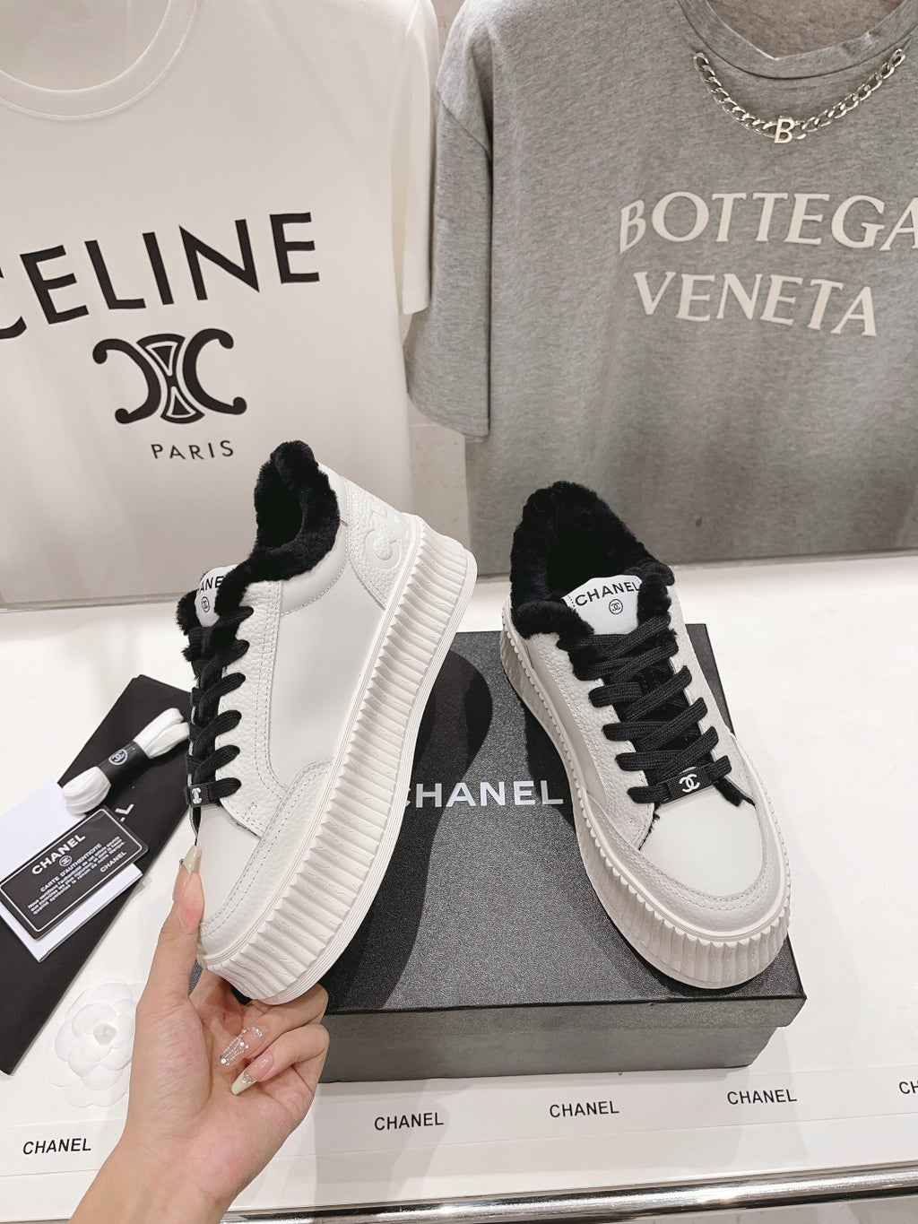 Women’s Chanel lace-up sneakers in white with black laces, plush collar, ribbed platform