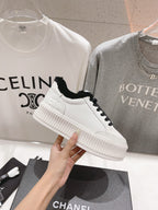 Women’s Chanel sneaker, white upper with black laces and plush collar, thick platform sole