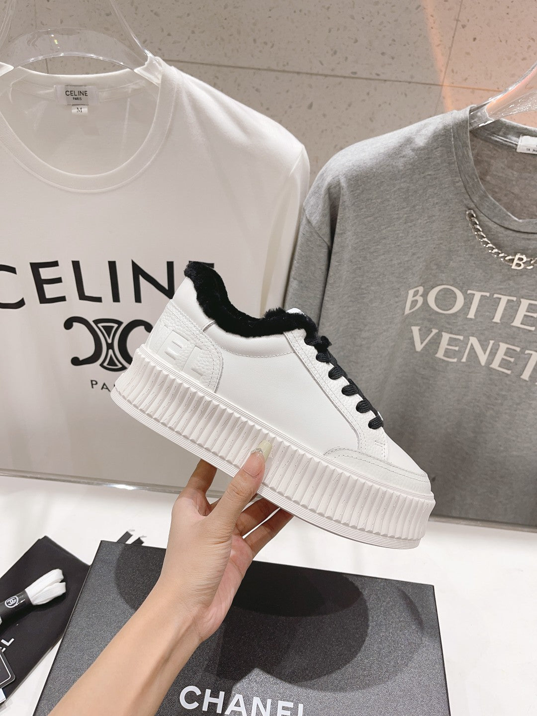 Women’s Chanel sneaker, white upper with black laces and plush collar, thick platform sole