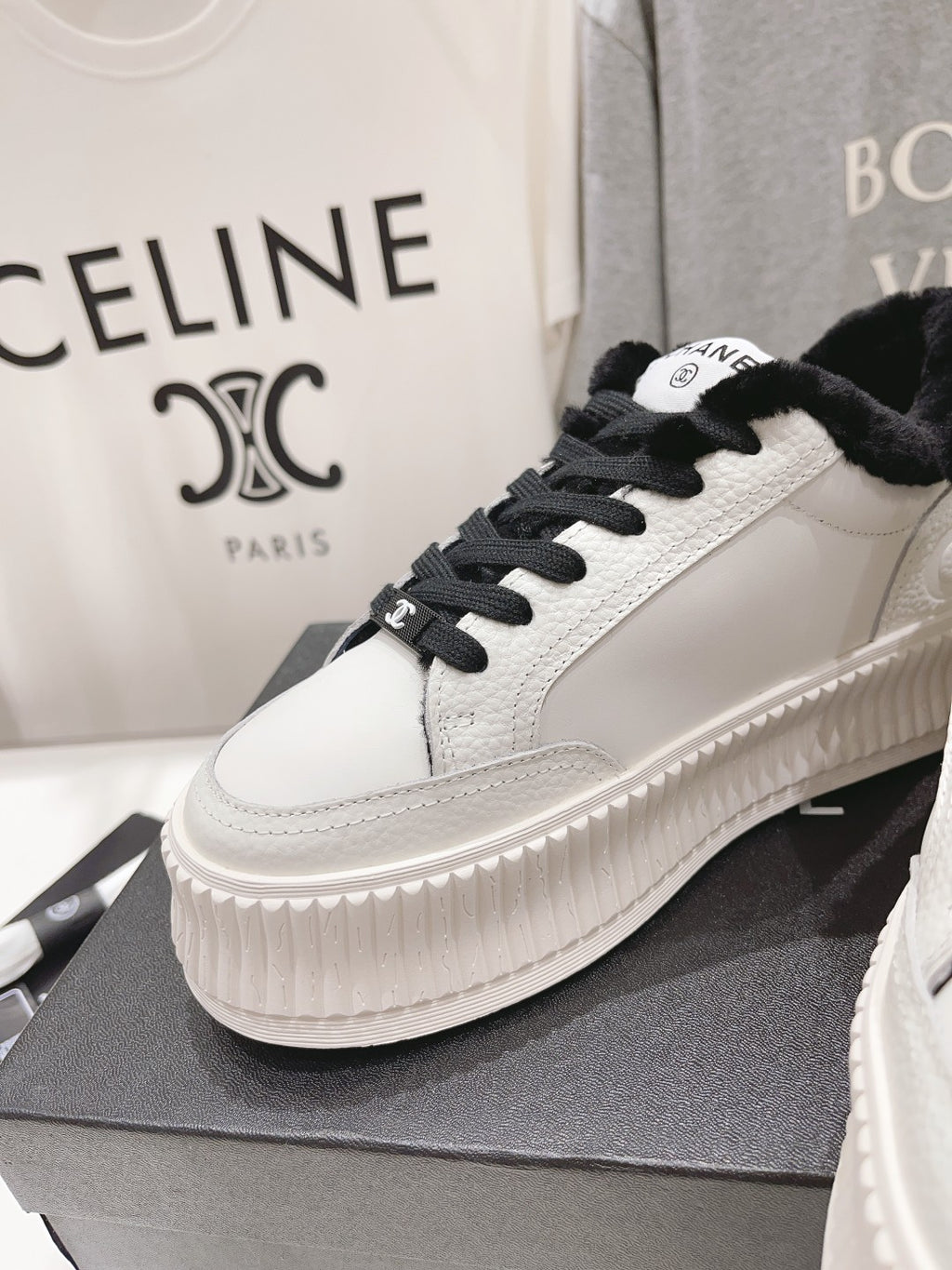 Women’s Chanel low-top sneakers, white with black laces, plush collar, ridged platform