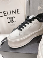 Women’s Chanel low-top sneakers, white with black laces, plush collar, ridged platform